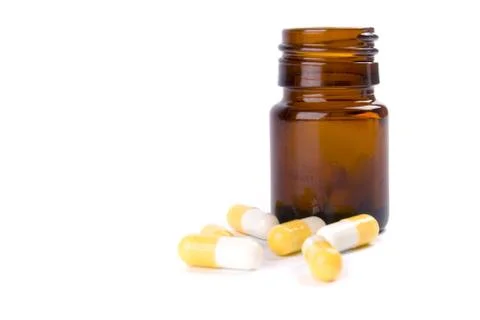 Bottle with yellow capsules Stock Photos
