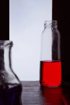 Bottled on a light background with blue and red liquid silhouette photo Stock Photos