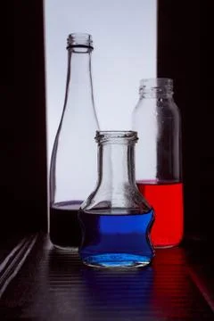 Bottled on a light background with blue and red liquid silhouette photo Stock Photos