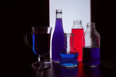 Bottled on a light background with blue and red liquid silhouette photo Stock Photos