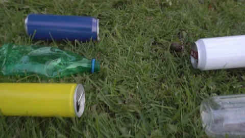 Bottles and cans are lying on the lawn Vídeos de archivo 120090233