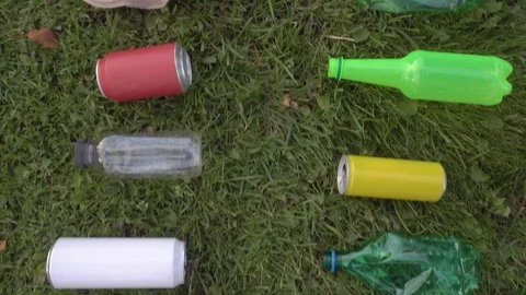 Bottles and cans lie in a row on the lawn Vidéo 120090229