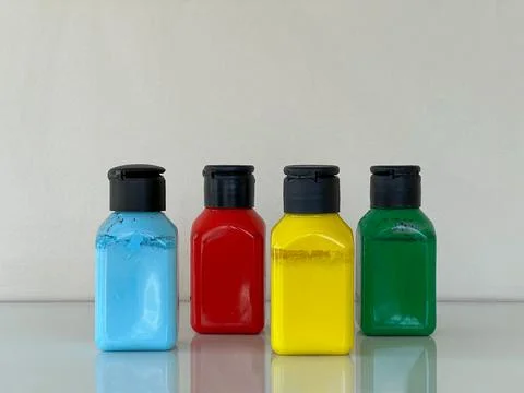 Bottles with bright multi-colored acrylic paint on a simple background Foto stock