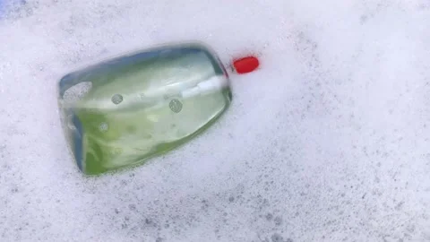 Bottles of detergents float in the foam. The concept of the dangers of household Stock-Footage 146720302