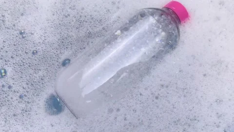Bottles of detergents float in the foam. The concept of the dangers of household Stock Footage 146720368