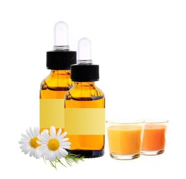 Bottles with essence oil, chamomiles and candles isolated on white Fotos de archivo