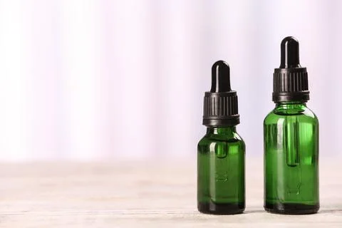 Bottles of essential oils on table against light background, space for text.  Stock Photos