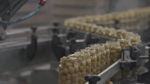 Bottles of olives circulating along a conveyor belt in a packaging factory Stock Footage 168643183