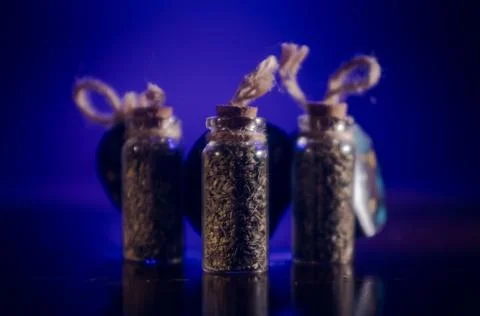 Bottles with spices stand in the mirror surface on a blue background Stock Photos