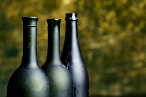 Bottles stand in a row on a table with a blurred golden background Stock Photos