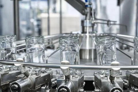 Bottles of vodka upside down transported by conveyor Stock Photos