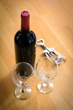 Bottles of wine with a corkscrew on wood table Stock Photos