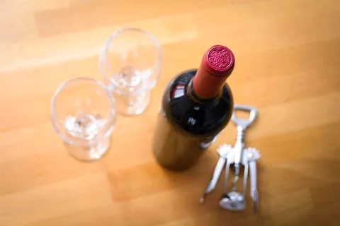 Bottles of wine with a corkscrew on wood table Stock Photos