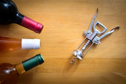 Bottles of wine with a corkscrew on wood table Stock Photos