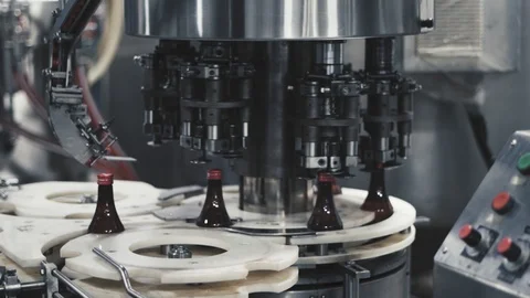 Bottling machine capping syrup bottles on conveyor lane in medicine Stock Footage 119257509