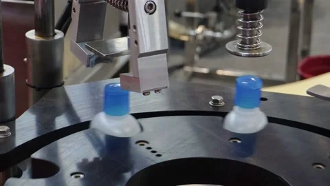 Bottling machine putting on caps on plastic alcohol bottle containers. Close up Stock Footage 198288005