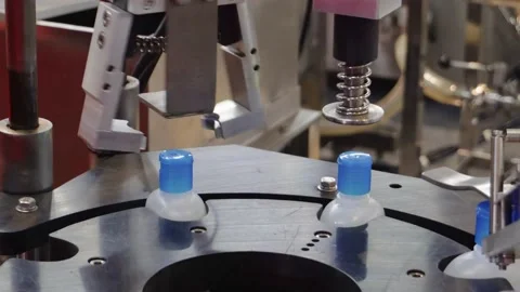 Bottling machine putting on caps on plastic alcohol bottle containers Stock Footage 198290614