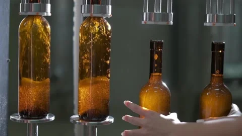 Bottling wine by the machine into bottles made of brown glass Stock Footage 141688455