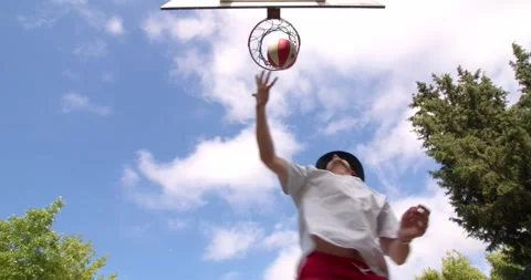 Bottom angle view metal net hanging outdoors with basketball ball falling in Stock Footage 244114277