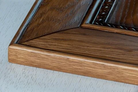Bottom corner of a classic lacquered solid wood kitchen facade with weaving a Stock Photos
