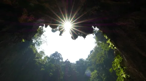 Bottom of deep hollow cave, looking up to sunstar shining through Stock Footage 50565007