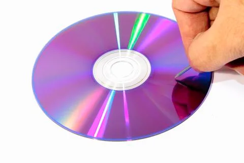 Bottom of a DVD with a nail ready to scratch it Stock Photos