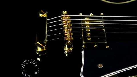 The bottom of the guitar with gold strings Stock Photos