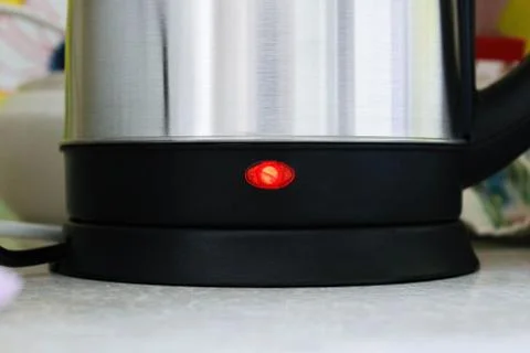 The bottom half of an electric kettle with a light bulb is turned on. Fotos Stock