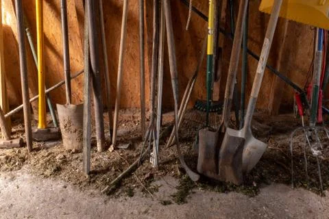 The bottom half of a selection of gardening tools including spade, fork, sled Stock Photos