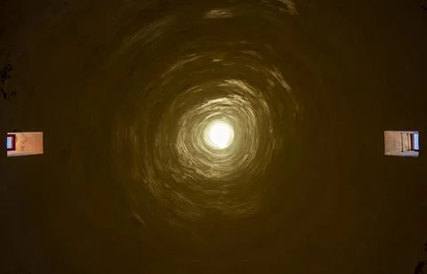 Bottom up image of a long chimney in an old building. Light penetrating from  Stock Photos
