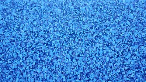 The bottom of a swimming pool made of multi-colored tiles under a layer of .. Stock Photos