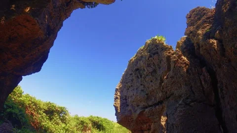 Bottom to top front to back view inside of rocky coral green valley look out to  Stock Footage 279140278