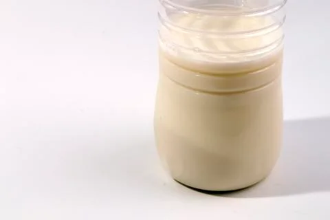 Bottom of the transparent plastic bottle half full of milk Stock Photos