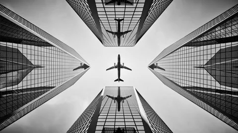 Bottom view airplane flying over skyscrapers and reflects in glass facades. Видео 98629741