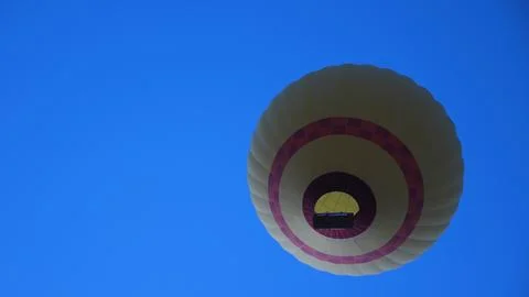 Bottom view of balloon flight with bright flame against blue sky. Unusual a.. Stock Photos