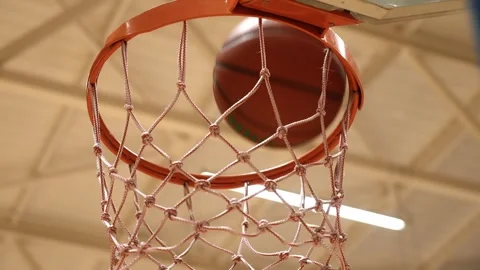 Bottom view of a basketball being thrown into the hoop. Basketball hoop and ball Stock Footage 255744044