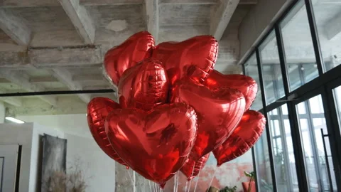 Bottom view of beautiful heart-shaped helium red balloons installed in some Stock Footage 169631317