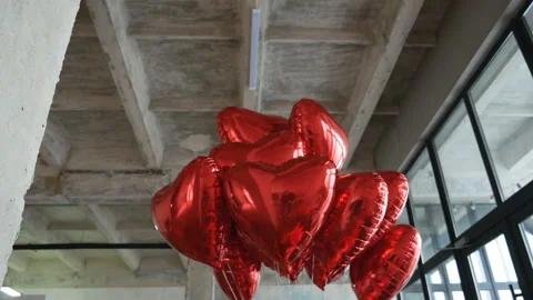 Bottom view of beautiful heart-shaped helium red balloons installed in some Stock Footage 171558268