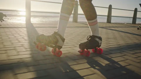 Bottom view of a black woman rollerskating on the broadwalk and playing Stock Footage 279341028