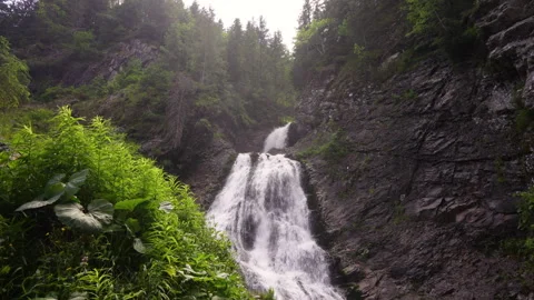Bottom view of Bride's Veil waterfall in Transylvania. Water vapor is carried  Stock Footage 307431271
