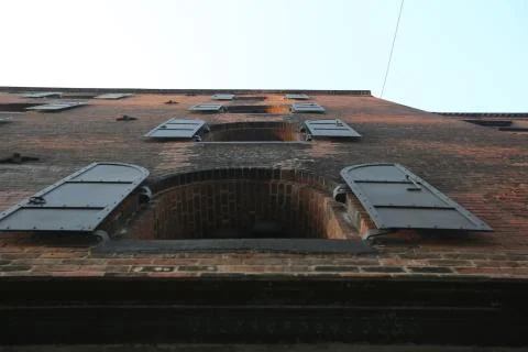 Bottom view of the building of brick which is connected by concrete with windows Stock Photos