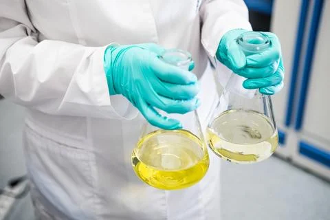 Bottom view of a chemist shaking yellow samples before analysis. Stock Photos
