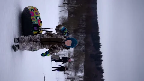 Bottom view Child pulls snow tubing up on mountain, sled, winter sport, activity Stock Footage 211626288