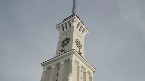 Bottom view of a clock tower with a long spire on blue cloudy sky background Vidéo 150107913