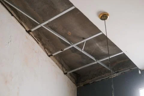 Bottom up view of collapsed plasterboard ceiling, moisture and rust caused ho Stock Photos