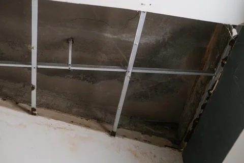 Bottom up view of collapsed plasterboard ceiling, moisture and rust caused ho Stock Photos