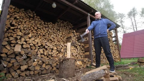 Bottom view of confused man with a log and a sharp vintage axe chop wood for Stock Footage 221571469
