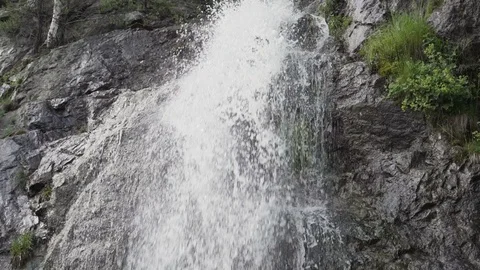 Bottom view of crystal clear waterfall crashing against mossy rocks Stock Footage 109621177