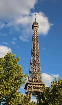 Bottom view of Eiffel tower in Paris France between the green trees Stock Photos