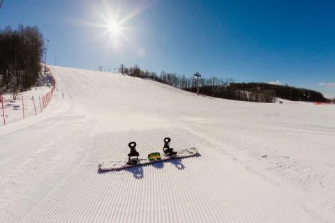 Bottom view on empty ski slope and equipment for snowboarding Stock Photos